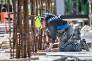 Een bouwvakker aan het werk op de bouwplaats van het Knippenbergcollegge